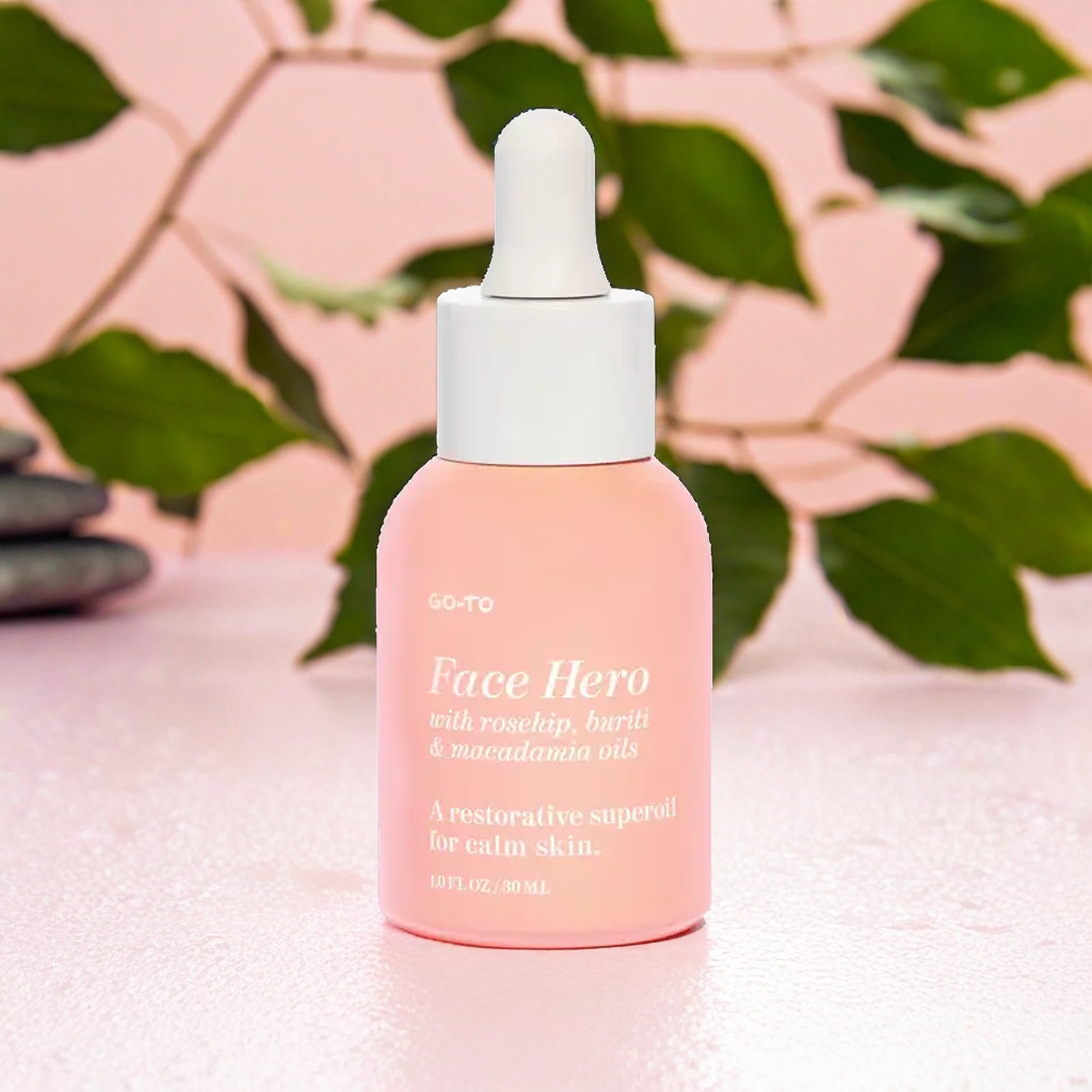 Background pink pastel dengan batu, kayu, dan daun-daun di sekelilingnya.